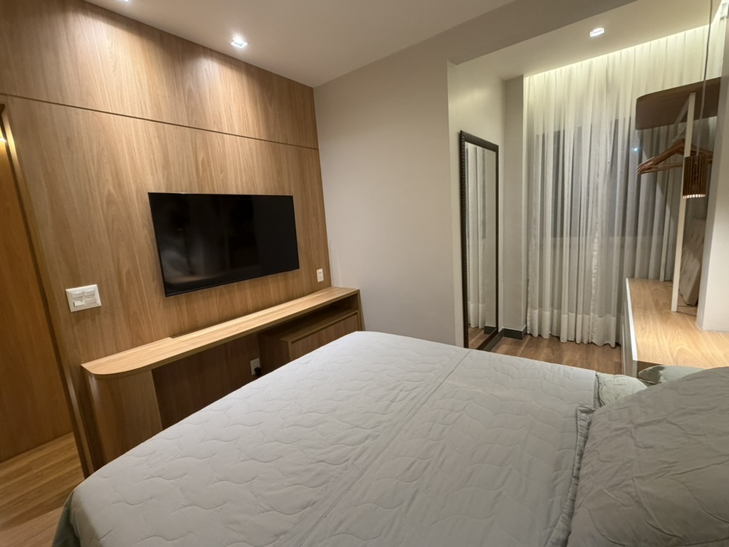 Reverse bedroom view with television wall and wood finishes