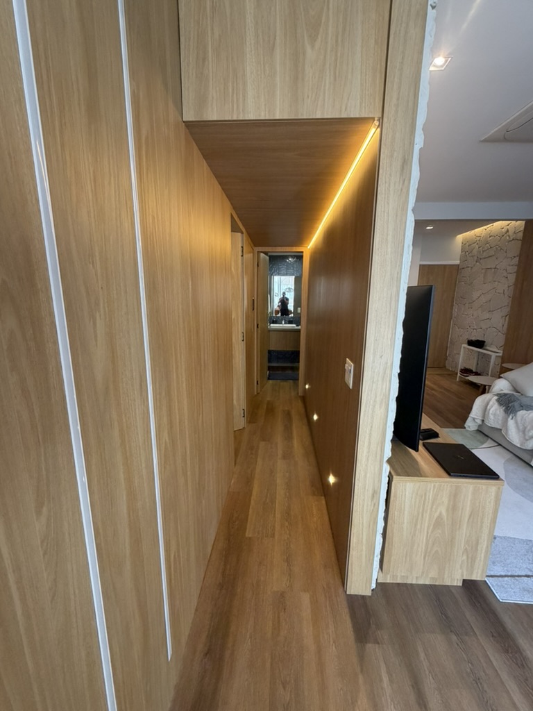 Wood-lined hallway with a continuous warm lighting detail